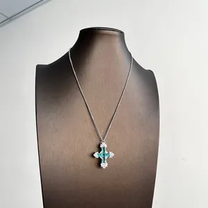 Détail d'un collier pendentif croix en argent avec pierres vert menthe et zircon