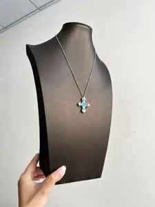 Détail du collier avec pendentif croix en zircone vert menthe sur buste de bijoux