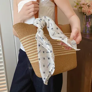 Detailed view of white polyester bandana with black stars tied to a woven bag handle