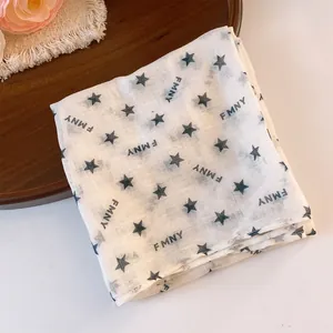 Detailed view of white polyester square bandana featuring black star and letter prints