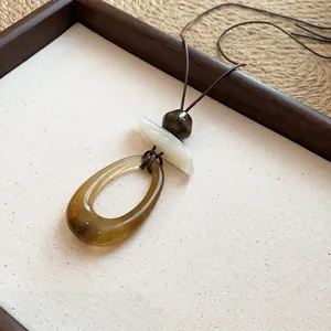 Artisanal irregular geometric resin pendant necklace with dark brown leather cord