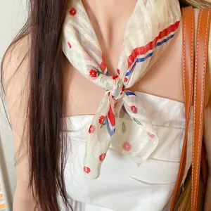 Close-up of a floral print polyester neck scarf tied in a stylish knot for a fresh look