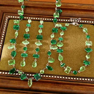 Vista detallada de un conjunto de joyas vintage con piedras de circón verde geométricas