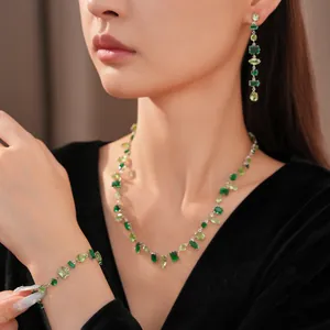 Vista detallada de un conjunto de joyas de lujo con circonitas verdes en una modelo asiática