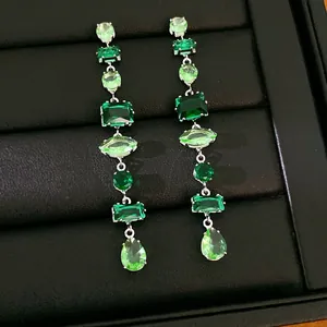 Vista macro detallada de elegantes pendientes largos de circonita verde esmeralda y menta