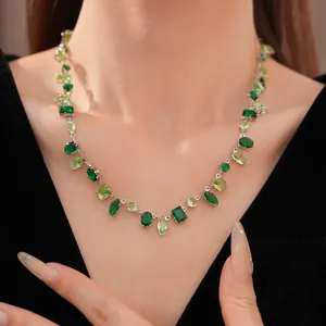 Detalle de un collar geométrico de lujo con circonitas verdes lucido por una modelo