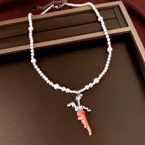 Detailaufnahme einer eleganten Perlenkette mit funkelndem Zirkon-Karottenanhänger auf braun
