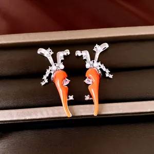 Detailaufnahme kreativer Karotten-Ohrringe mit Perlen und funkelnden Zirkonia-Steinen.