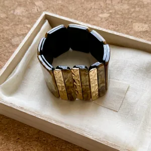 Primer plano de pulsera geométrica de resina con carey y detalles texturizados
