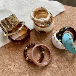 Elegante colección de brazaletes de resina con tachuelas en diversos colores y estilos