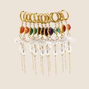 Detailed view of colorful acrylic and pearl tassel earrings in 18K gold plated steel.