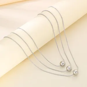 Triple-layered silver titanium steel snake chain necklace with round bead pendants.