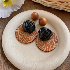 Bohemian vintage earrings with wood studs, leather roses, and engraved wooden discs