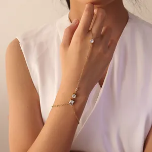 Elegante pulsera de mano de acero inoxidable dorado con circonitas blancas en la mano