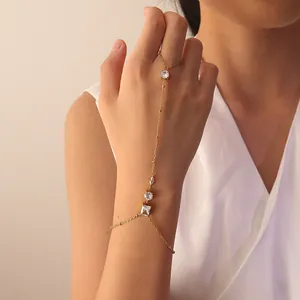 Detalle de elegante cadena de mano de acero dorado con piedras de circonita blanca
