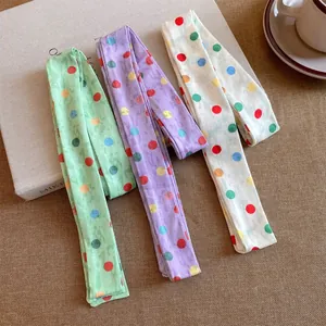 Set van drie kleurrijke polyester lint sjaals met stippen in groen, paars en crème wit.
