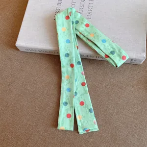 Detailopname van lichtgroene polyester sjaalketting met kleurrijk polkadots patroon