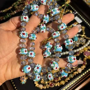 Collier réglable en perles d'acrylique bleu avec motifs de fleurs blanches et fermoir à bascule doré