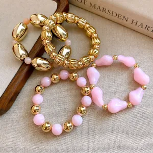 Elegante conjunto de pulseras elásticas de acrílico rosa y dorado para mujer.
