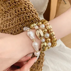 Detalle del conjunto de pulseras elásticas con perlas acrílicas blancas y cuentas oro