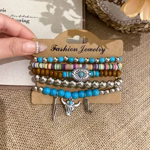Detail of boho beaded bracelet set with bull head and feather charms in ethnic style.