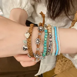Close-up of bohemian layered bracelet set featuring leather braids and colorful beads.