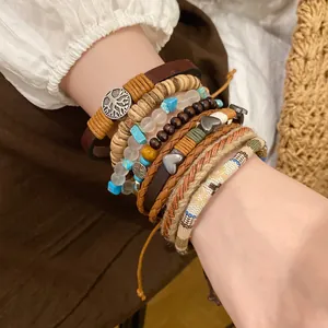 Close-up detail of bohemian multilayer bracelet set featuring wood beads and leather