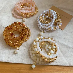 Close-up of elegant acrylic pearl beaded bracelet set in multiple warm colors