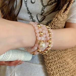 Close-up of elegant pink and gold beaded bracelet set with a large pearl charm