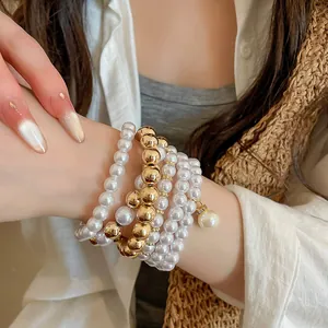Close-up view of elegant acrylic pearl and gold metallic beaded bracelet set for women