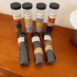 Detail van kleurrijke elastische haarelastiekjes in plastic opbergbuisjes