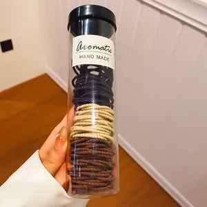 Gedetailleerde opname van gekleurde elastische haarelastiekjes in een cilinderbuis