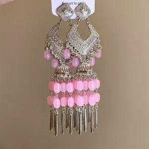 Gros plan de boucles d'oreilles vintage en argent avec perles roses et franges