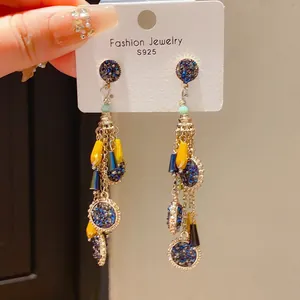 Vue détaillée de boucles d'oreilles vintage à pampilles avec strass bleus et jaunes