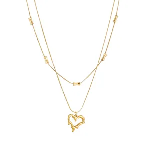 Close-up detail of double-layer gold stainless steel necklace with irregular lava heart pendant