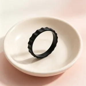 Macro detail view of a minimalist matte black industrial gear-shaped stainless steel ring
