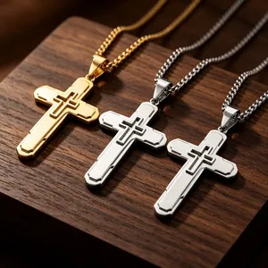 Dettaglio macro dei ciondoli a croce cavi a doppio strato in oro e finitura acciaio