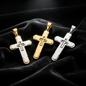 Dettaglio di tre ciondoli a croce a doppio strato in acciaio al titanio, colori oro e argento.
