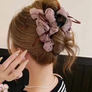 Korean style brown striped fabric ruffle hair claw clip with tassel ribbons on model