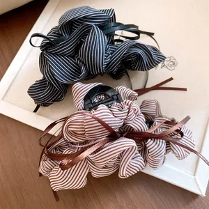Close-up detail of Korean style striped fabric bow hair claw clips in black and brown