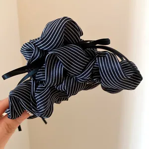 Detailed view of black and white striped ruffled bow hair claw clip with tassels.