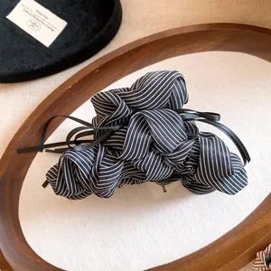 Detail view of the striped fabric and delicate black ribbons on this hair claw clip