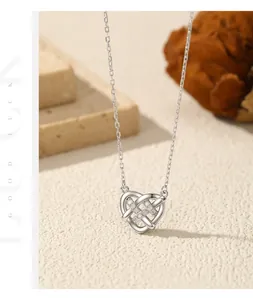 Detailopname van een zilveren gevlochten hartjesketting met fonkelende moissaniet