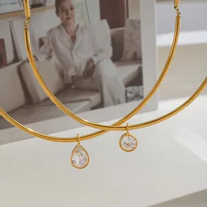 Close-up of 18K gold plated stainless steel choker with round and drop crystal pendants.