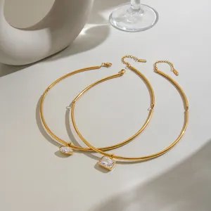 Detail of two stainless steel 18K gold plated choker necklaces with solitaire crystals