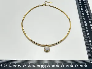 Close-up of gold stainless steel choker necklace with a single round zircon pendant.