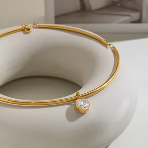 Close-up of a minimalist stainless steel 18k gold plated choker with single stone pendant
