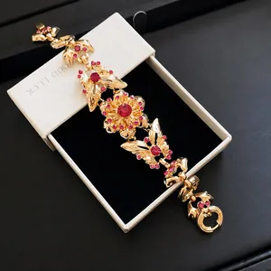 Vintage Armband in Goldoptik mit Schmetterlings- und Blumenmotiven und rosa Strass