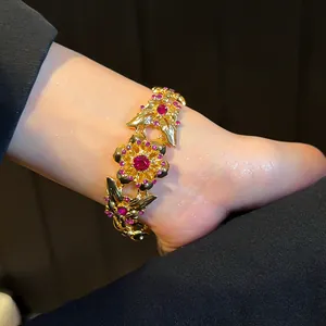 Detailansicht eines Vintage-Goldarmbands mit Schmetterlings- und Blumenmuster