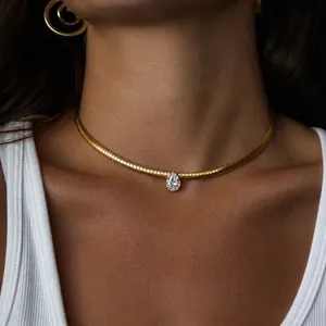 Detailaufnahme einer goldenen Schlangenkette mit birnenförmigem Zirkon-Anhänger